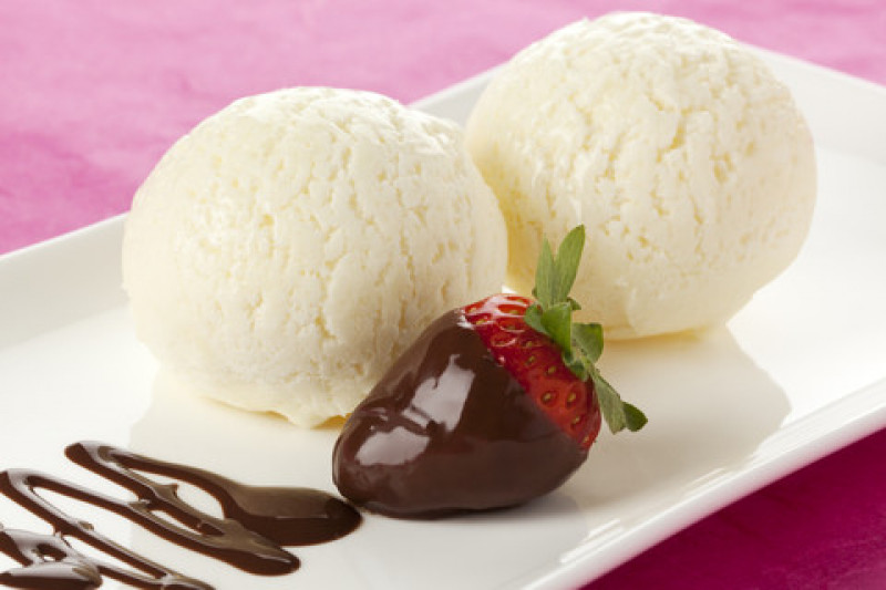 tagAlt.Two scoops of vanilla ice cream decorated with chocolate dipped strawberry